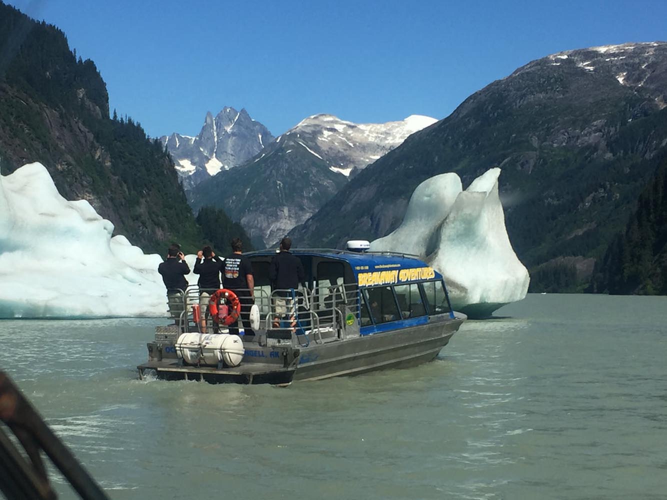 a group of people in a boat on the side of a mountain