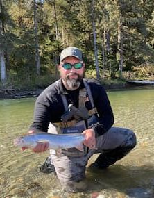 a man holding a fish in the water